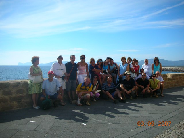 Il mega gruppo della settimana blu in visita ad Alghero, in posa sui bastioni, con il mare che fa loro da sfondo!